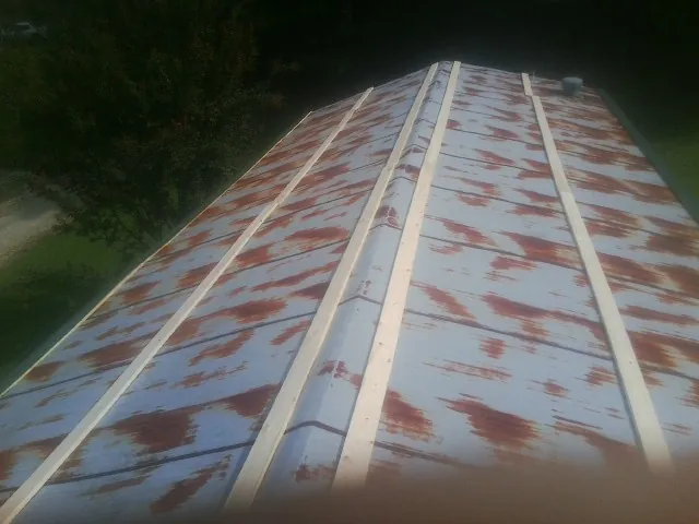 Rusted metal roof panels with new wood purlins before replacement — Storm Damage Roof Repair in Murphysboro by Roofing Brothers